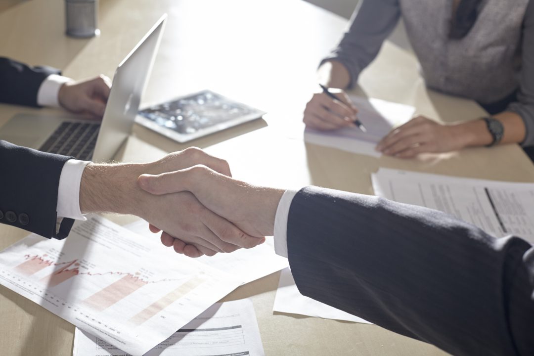 テーブル上で握手するビジネスマン